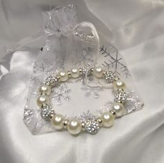 Introducing this Dazzling Rhinestone Snowball and Pearl Bracelet by Daily Blessings™.  This beautiful bracelet will send you out for the evening looking absolutely elegant. Wear your blessings proudly with this sparkling stretch bracelet.  10mm Rhinestone Snowballs and Pearls #blessings #grateful #thankful #customjewerly Luxury Dazzling White Bracelets, Dazzling White Bracelet Perfect For Gifts, Elegant Adjustable Crystal Stretch Bracelet, Elegant Crystal Stretch Bracelet For Gift, Elegant Bracelets With Rhinestone Round Beads, Elegant Crystal Bracelet With Rhinestones, Elegant Crystal Bracelet With Rhinestones For Gift, White Crystal Bracelet With Rhinestones As Gift, Elegant Rhinestone Crystal Bracelet As Gift