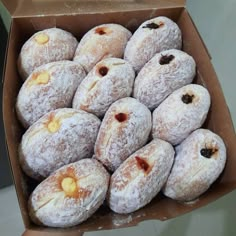 a box filled with powdered sugar covered donuts