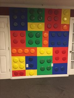 a colorful wall made out of legos in a room with doors and carpeting