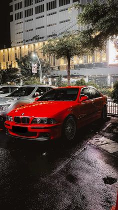 a red car parked in front of a tall building