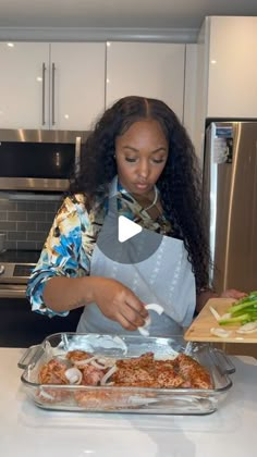 a woman standing in front of a counter cutting up food on top of a pan