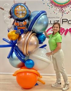 a woman standing next to a balloon sculpture