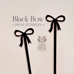 two black bow drink stirrers with bows on them