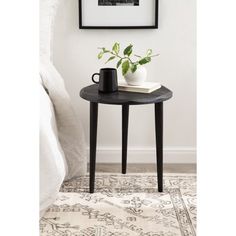 a small table with a coffee cup and plant on it