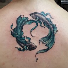 a man with a tattoo on his back that has two fish swimming in the water