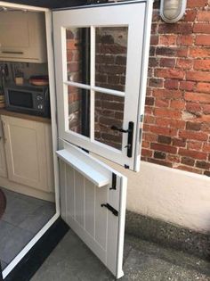 an open door on the side of a brick wall in front of a kitchen area