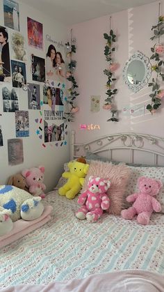 there are many stuffed animals on the bed in this girls's room with pink walls