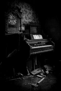 an old piano sitting in the corner of a room with peeling paint and debris on the floor