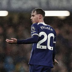 a soccer player is holding his hands out in the rain