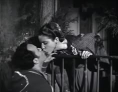 two people kissing each other on the balcony