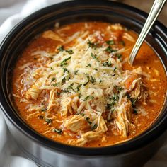 a close up of a bowl of soup with meat and cheese in it on a table