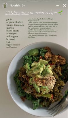 a white bowl filled with salad and topped with avocado on top of a table