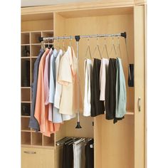 an open closet with clothes hanging on hooks