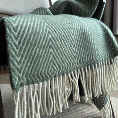 a green and white blanket sitting on top of a chair