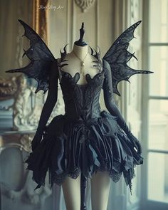 a mannequin dressed in black with wings