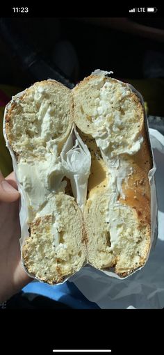 a person holding up a piece of bread with cream on it