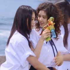 two girls are hugging each other while one girl is holding a toy in her hand