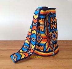 a multicolored bag sitting on top of a wooden table