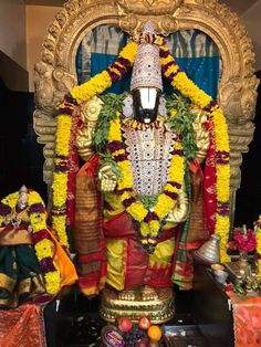 the statue is decorated with flowers and garlands