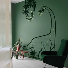 a green room with a dinosaur painted on the wall and a chair in front of it