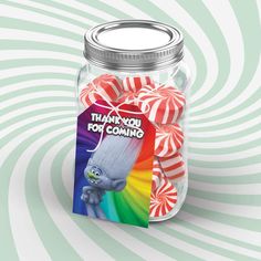 a jar filled with candy canes on top of a green and white striped background