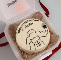 a cake in a plastic container with writing on the side and an image of a man's torso