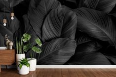 a black and white wallpaper with large green leaves on it in a living room