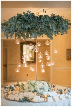 a table topped with a vase filled with flowers and lots of bubbles hanging from the ceiling