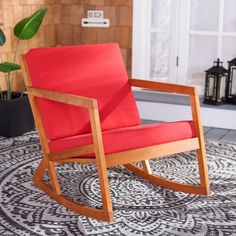 a red rocking chair sitting on top of a rug