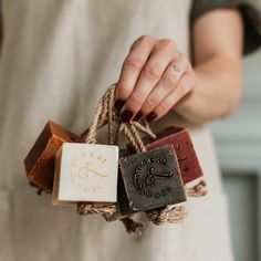 a woman holding three soap bars tied up to each other with twine on them