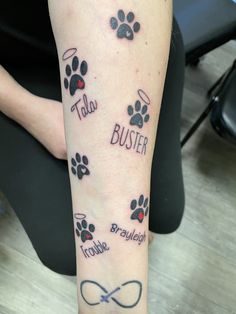 a person with a tattoo on their arm that has dogs paws and name tattoos