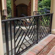 an iron railing on the outside of a brick building with a fireplace in the background