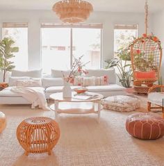 a living room filled with lots of furniture and plants