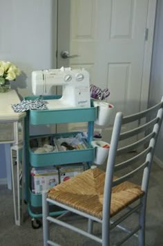 a sewing machine sitting on top of a blue table next to a white desk and chair