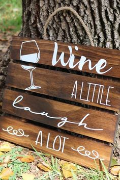 a wooden sign that says wine, little laugh, and a lot less on it