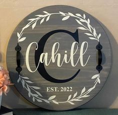 a wooden sign with the word call on it next to a vase and flower arrangement