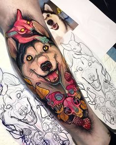 a person with a tattoo on their leg that has a wolf and flowers on it