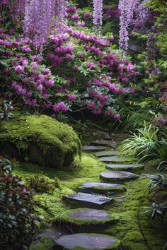 stepping stones in the middle of a garden with purple flowers hanging from it's branches