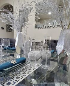 a glass table topped with crystal vases and trees