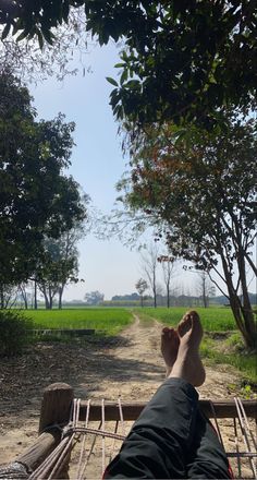 a person laying in a hammock with their feet up