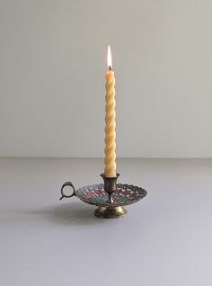 a single candle sitting on top of a plate