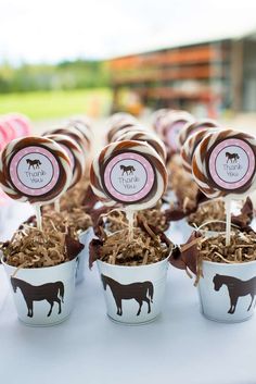 there are many desserts in small white cups on the table with brown and pink candies