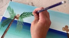 someone is painting a palm tree on the beach