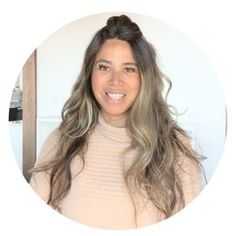 a woman with long hair wearing a turtle neck sweater smiling at the camera in front of a white background