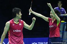 two men holding tennis racquets high in the air