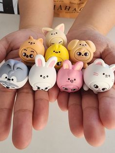 a person is holding small animal erasers in their hands with the faces of animals painted on them