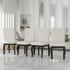 a set of four white upholstered dining chairs