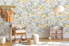 a baby's room with lemons and leaves on the wall, including a rocking chair