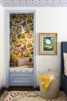 a room with a blue bench and floral wallpaper on the walls next to a painting