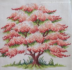 a cross stitched picture of a pink tree